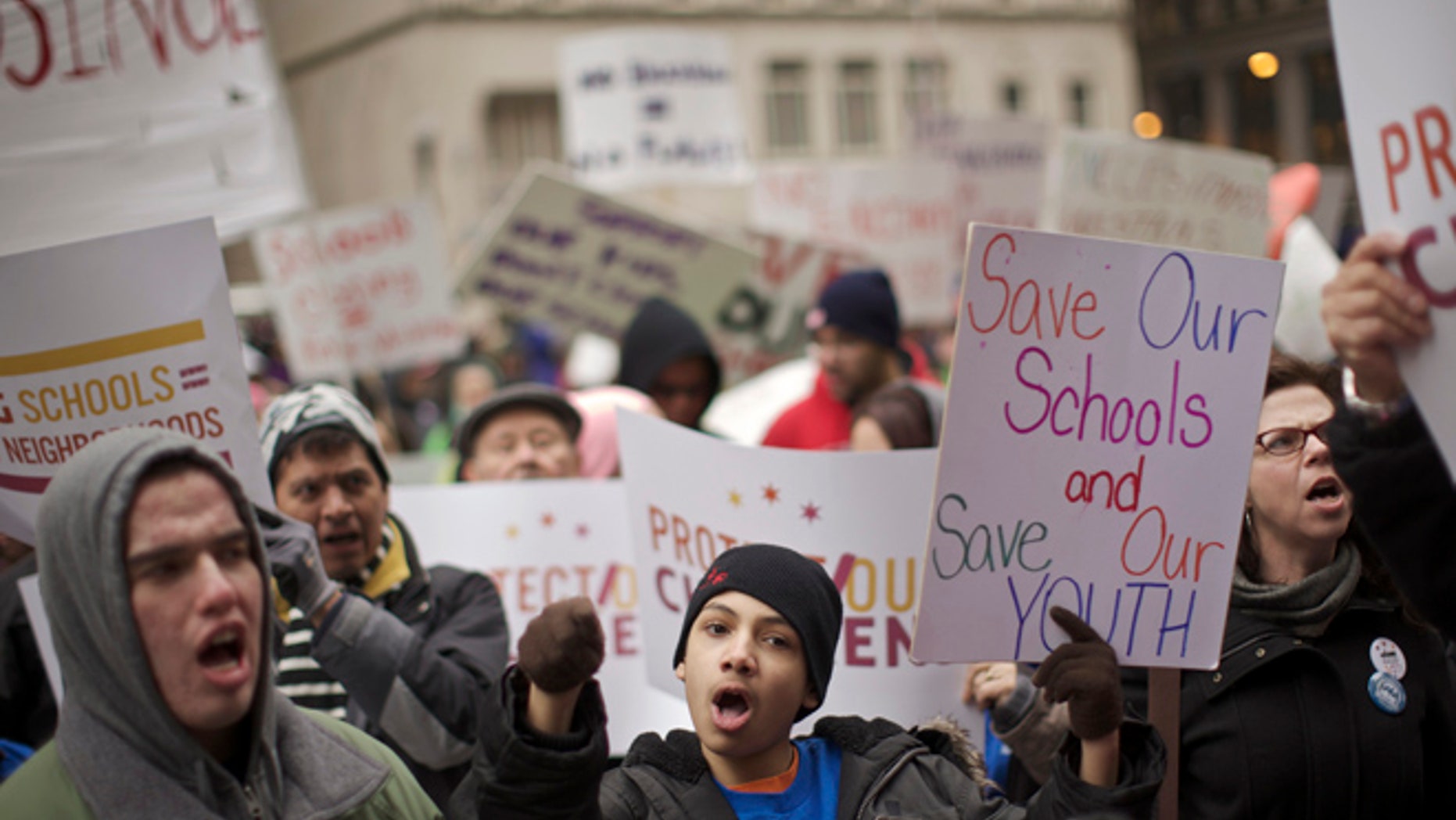 Demonstrators hold placards during a Chicago Teachers Union protest in Chicago March 27, 2013. Thousands of demonstrators rallied in downtown Chicago on Wednesday to protest the city's plan to close 54 public schools, primarily in Hispanic and African-American neighborhoods. The closings, which the school board plans to vote on in May, would be the biggest one-time shutdown ever by a U.S. city. Wednesday's demonstration, organized by the teacher's union, drew parents, students and other critics of the plan. REUTERS/John Gress (UNITED STATES - Tags: EDUCATION POLITICS SOCIETY CIVIL UNREST) - RTXY05T