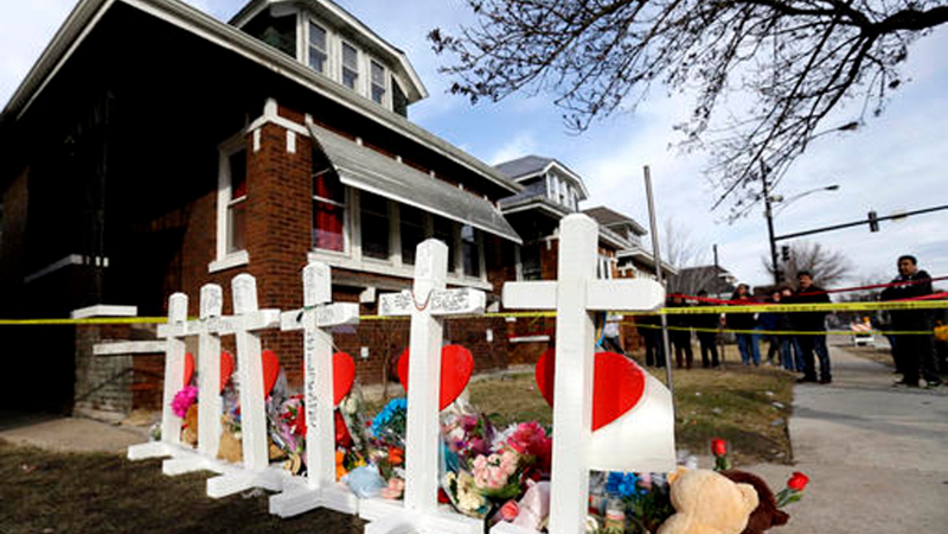 In this Feb. 7, 2016 file photo, mourners pay their respect outside a home in Chicago where six family members were found dead.