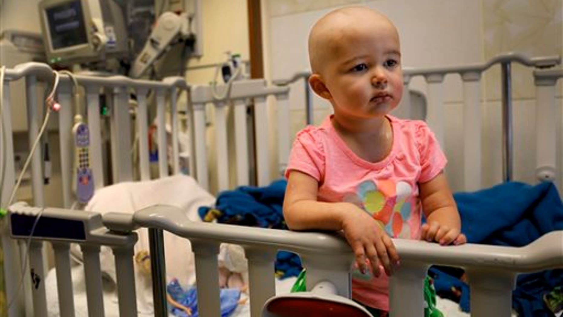 In this June 11, 2015 photo,Talia Pisano stands in her bed at Lurie Children's Hospital in Chicago. Talia is getting tough treatment for kidney cancer that spread to her brain. She's also getting a chance at having babies of her own someday. (AP Photo/Christian K. Lee)