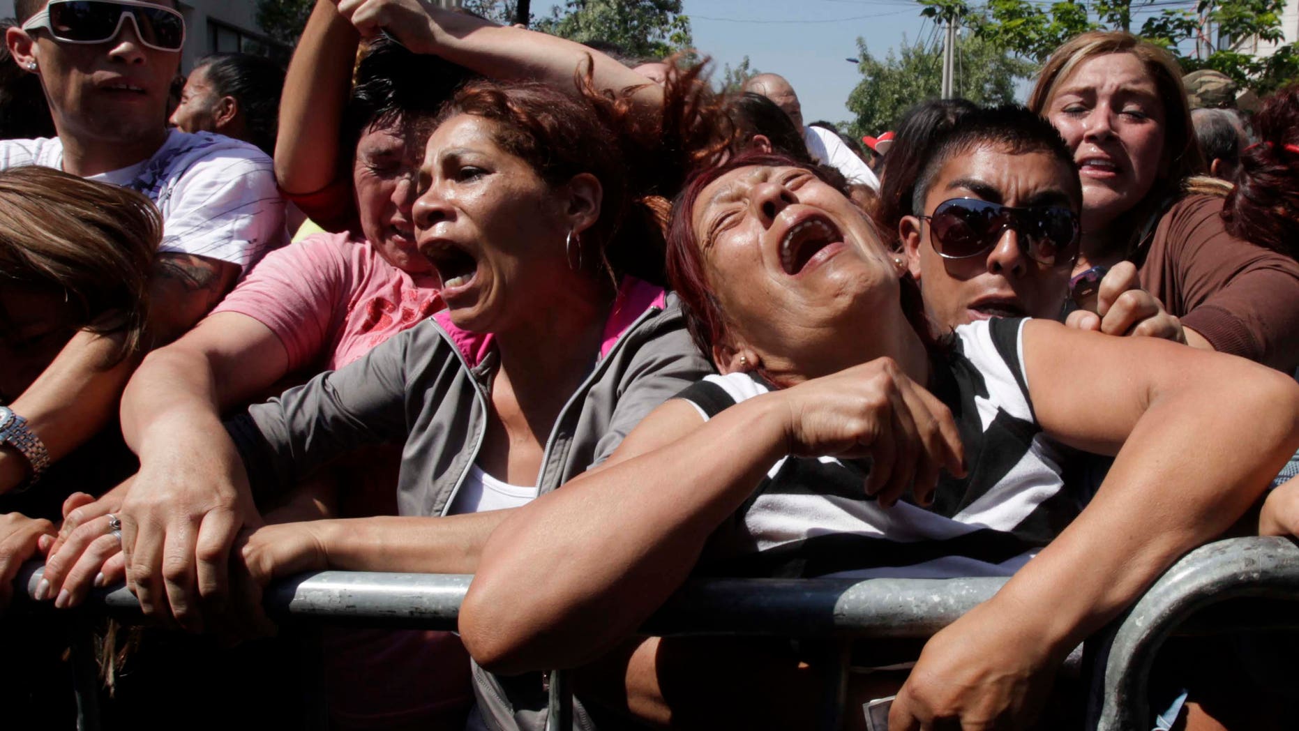 Relatives of inmates at the San Miguel prison react as they listen to the list of names of inmates who died in a fire in Santiago, Chile, Wednesday Dec. 8, 2010. A prison fire set off during a riot killed at least 83 inmates at the Chilean prison on Wednesday and seriously injured at least 14 others, firefighters said. (AP Photo/Aliosha Marquez)