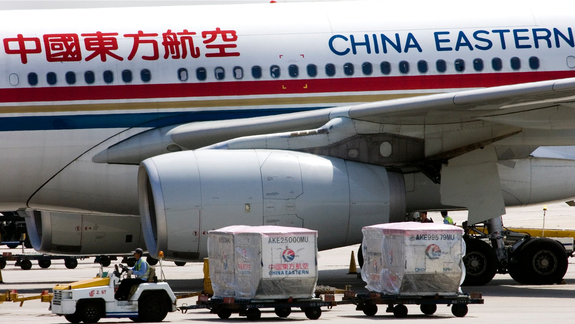 Aug. 29, 2007: A carter drives past a China Eastern airliner parked at the Beijing International Airport in Beijing, China.