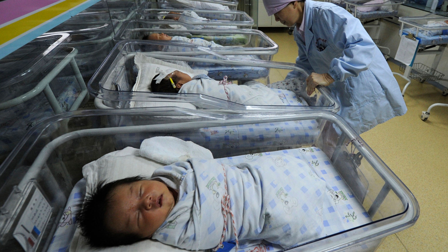 A nurse takes care of newborn babies at a hospital in Hefei, Anhui province April 2011.