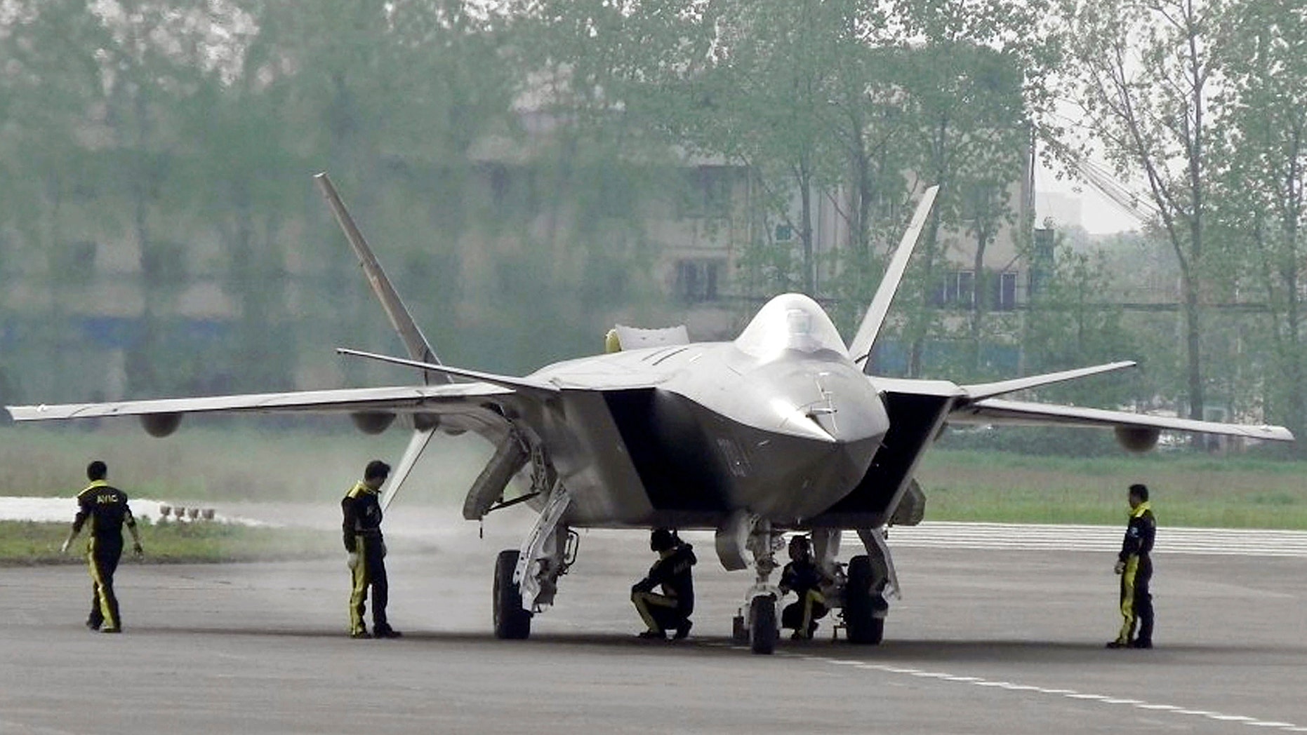 FILE - In this April 17, 2011 file photo, Chinese ground crew members inspect a J-20 stealth fighter in Chengdu, in southwest China's Sichuan province. China's defense budget will rise 8 percent to 1.1 trillion yuan ($173 billion) this year as the country is preparing to launch its second aircraft carrier, integrating stealth fighters into its air force and fielding an array of advanced missiles able to attack air and sea targets at vast distances, according to a report released Monday, March 5, 2018. (Color China Photo via AP, File)