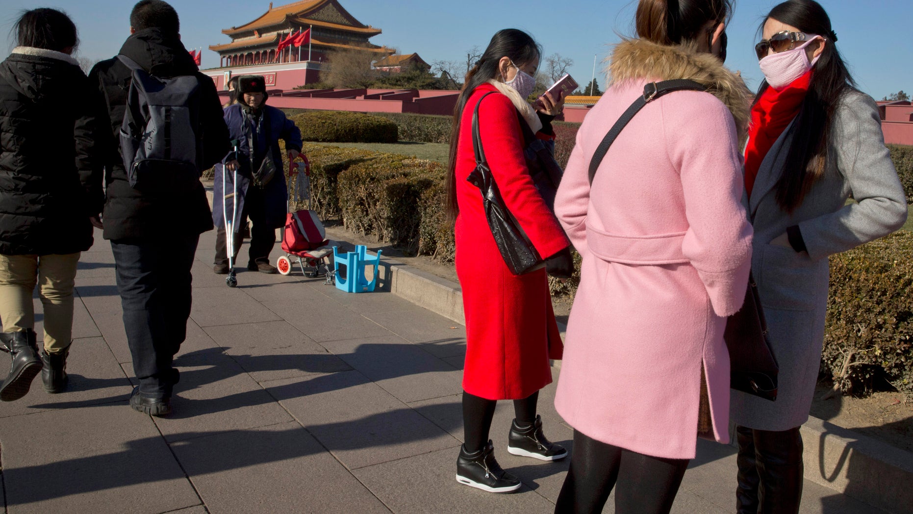 Dec. 18, 2015: Visitors to Tiananmen Gate wear masks during a blue sky day in Beijing. Residents in the Chinese capital are preparing for its second smog red alert as a wave of smog is forecasted to settle over the city from Saturday to Tuesday. (AP)