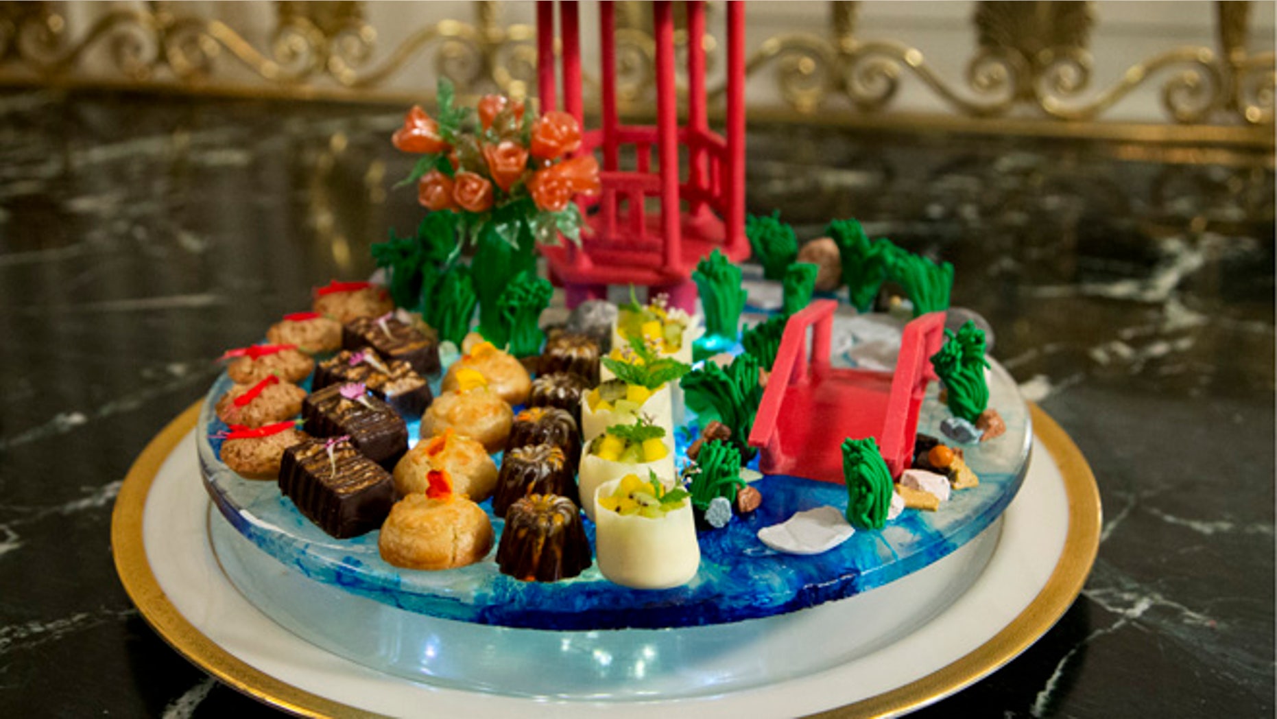 Sept. 24, 2015: The dessert called "a stroll through the garden" composed of handmade chocolate pavilion and bridge, pulled sugar roses, and white lotus flowers, that symbolize good fortune, is shown during a preview in the State Dining Room of White House in Washington for the state dinner of the visiting Chinese President Xi Jinping.(AP)