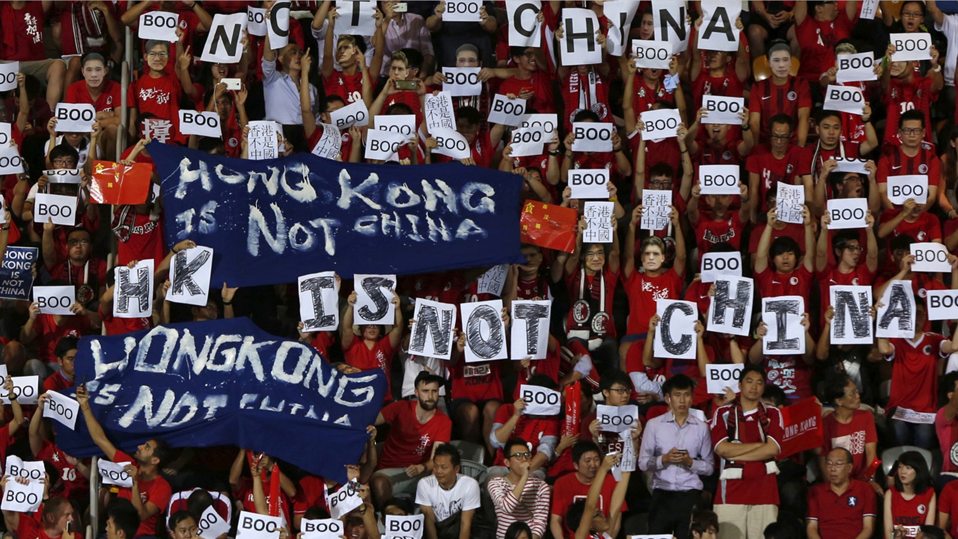 FILE: Hong Kong fans hold banners and character signs which read "Hong Kong is not China", during the 2015 World Cup qualifying match between Hong Kong and China, in Hong Kong.