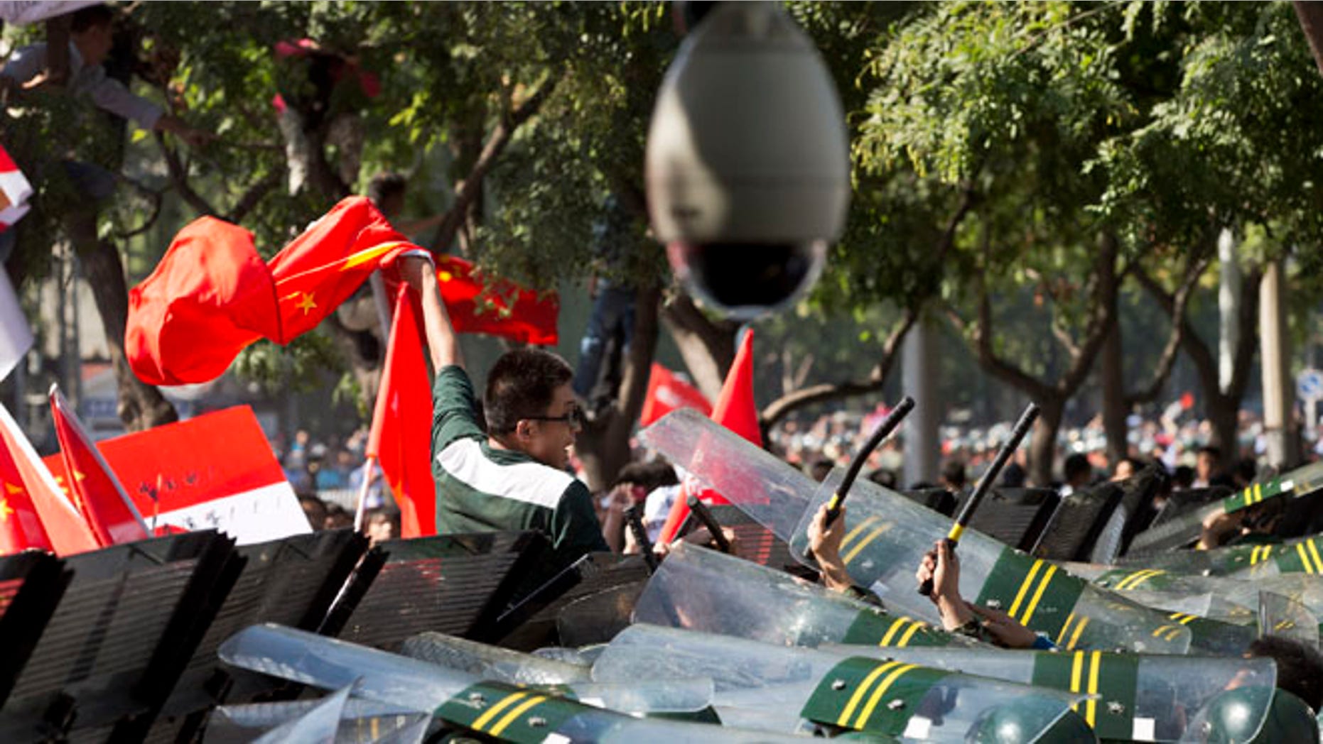 Sept. 15, 2012: A Chinese demonstrator climbs over the fence and chants slogans during an anti-Japanese protests outside the Japanese Embassy in Beijing.