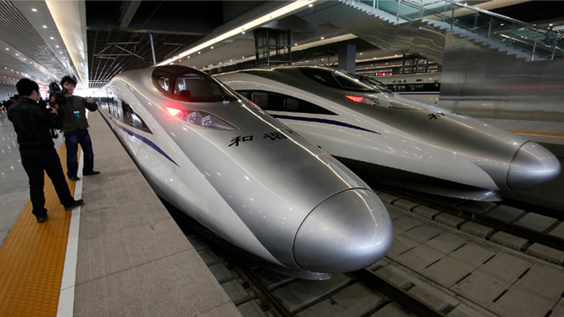 Journalists photograph the bullet trains of a new high-speed railway linking Shanghai with Hangzhou Tuesday, in Shanghai, China.