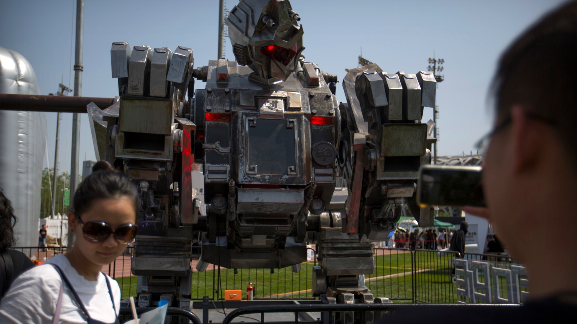 Visitors look at a giant robot named The Monkey King at the G Festival, part of the Global Mobile Internet Conference (GMIC) in Beijing, Saturday, April 29, 2017. The GMIC features current and future trends in the mobile Internet industry by some major foreign and Chinese internet companies. (AP Photo/Mark Schiefelbein)