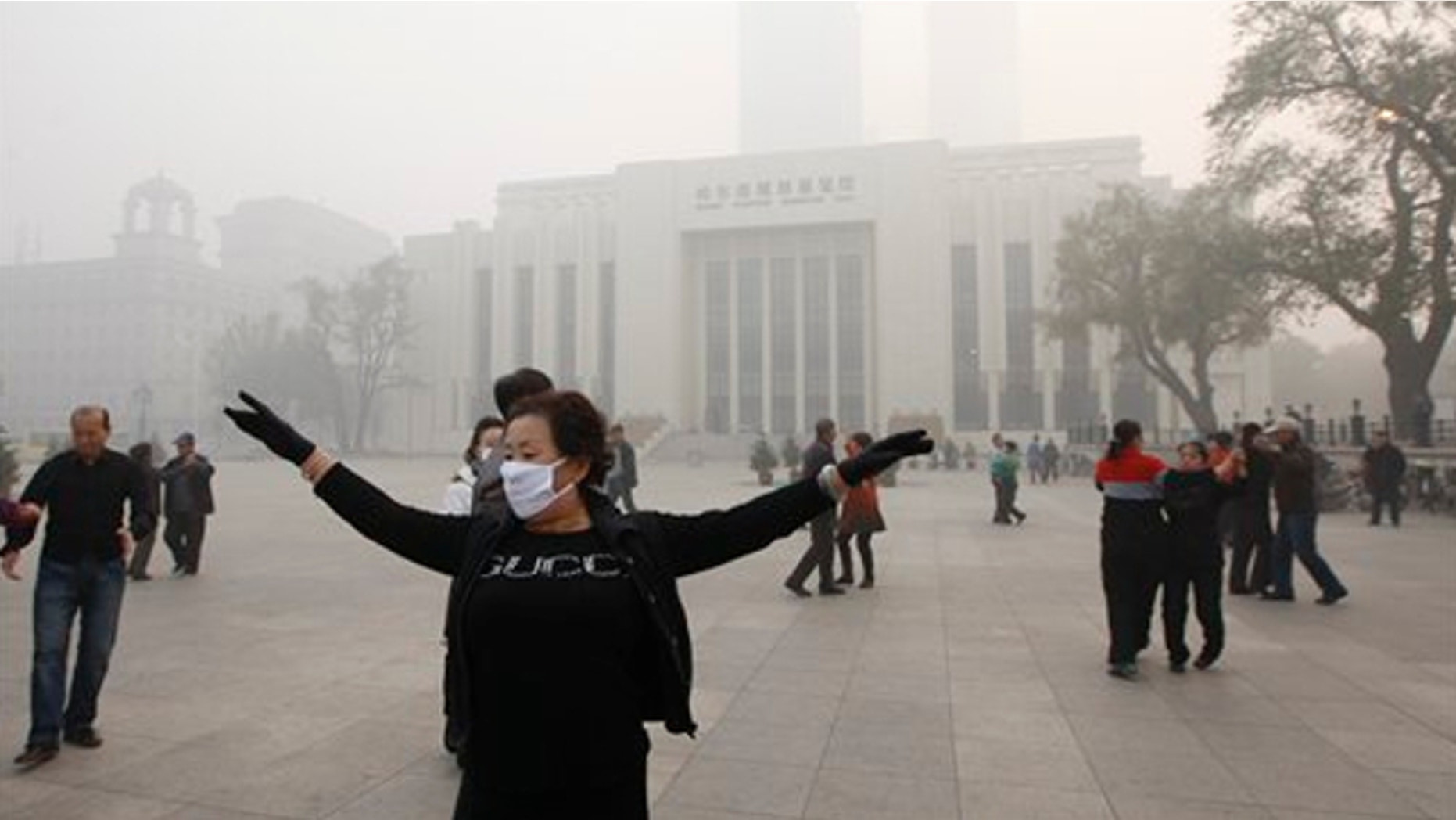 Oct. 21, 2013: A Chinese woman wears a mask as she takes part in communal dancing during a day of heavy pollution in Harbin in northeast China's Heilongjiang province.