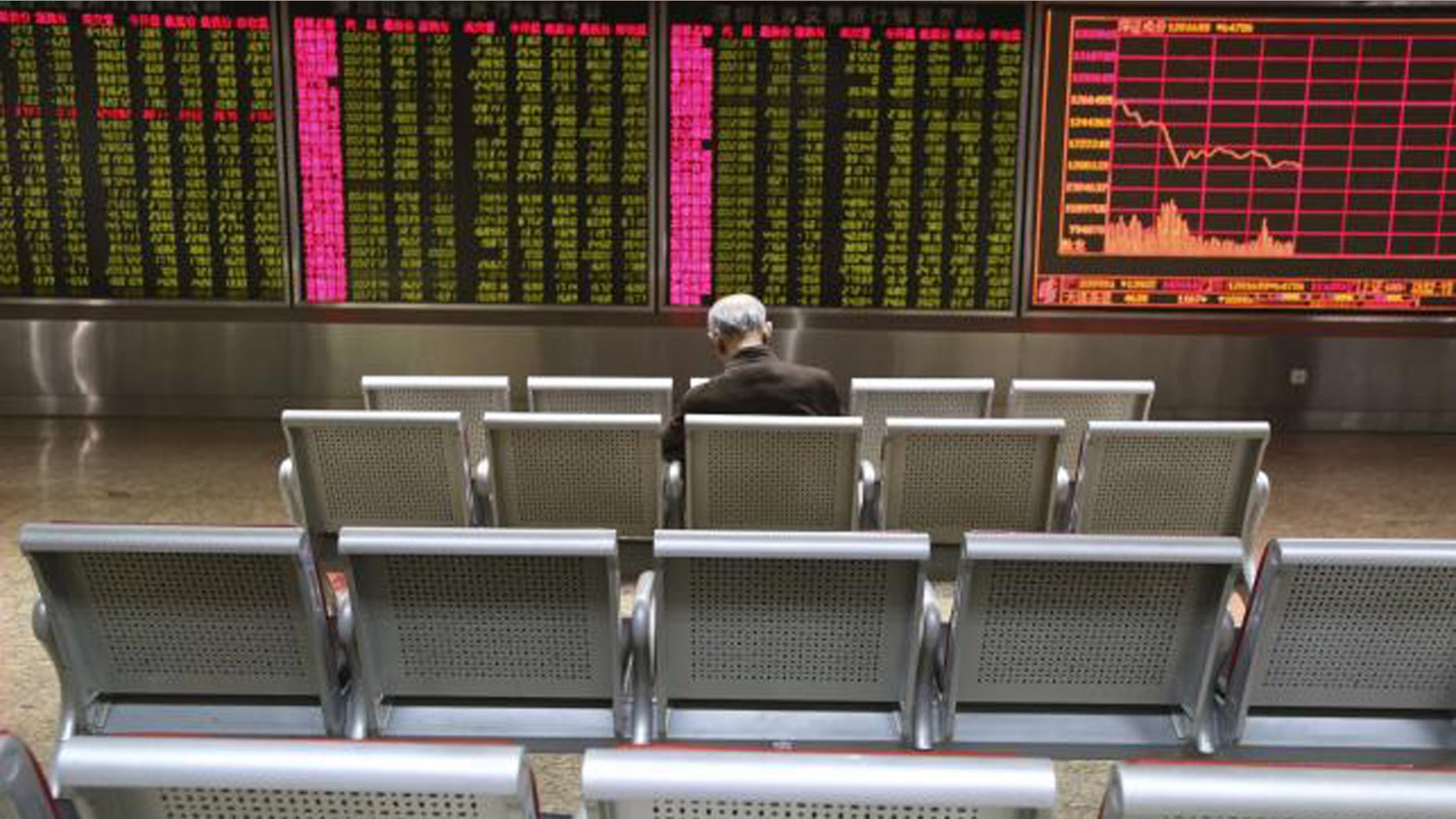 Jan. 4, 2016: An investor sits in front of a display board showing stock information at a brokerage house in Beijing. (Reuters/Li Sanxian)