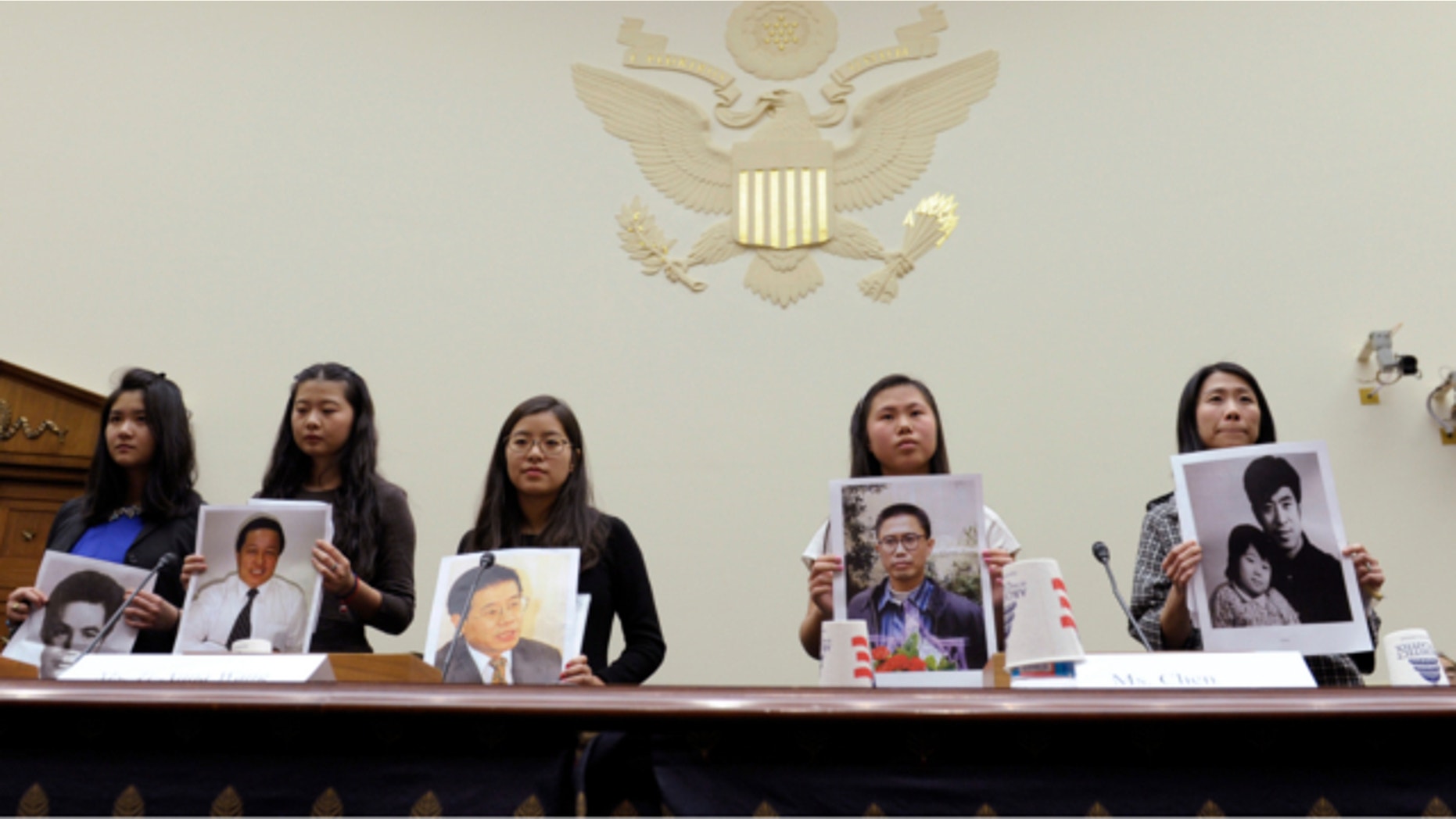Dec. 5, 2013: From left, Lisa Peng, holding a photo of her father Peng Ming, Grace Ge Geng, holding photo of her father Gao Zhisheng, Ti-Anna Wang, holding photo of her father Wang Bingzhang, Bridgette Chen holding photo of her father Liu Xianbing, and Danielle Wang, holding photo of her father Wang Zhiwen, are introduced prior to testifying before the House Foreign Affairs Committee hearing entitled, "Their Daughters Appeal to Beijing: 'Let Our Fathers Go,! on Capitol Hill in Washington.