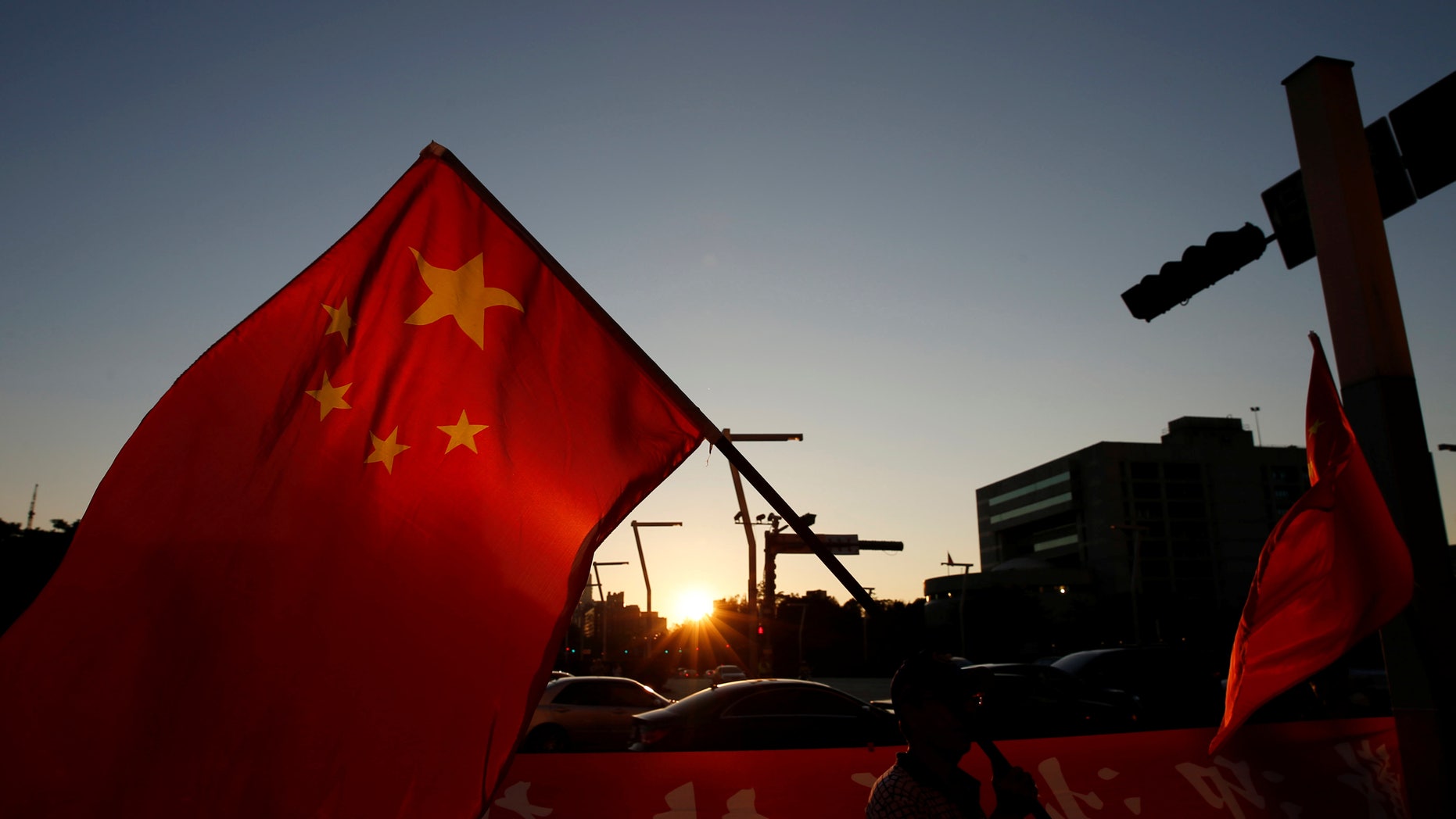 A pro-China supporter holds Chinese national flag, outside the dinner venue of Sha Hailin, a member of Shanghais Communist Party standing committee, in Taipei, Taiwan August 22, 2016. (REUTERS/Tyrone Siu)