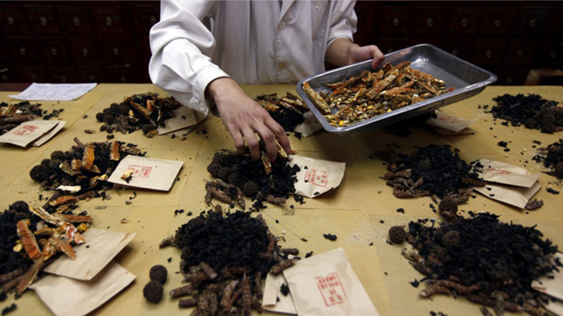 A worker prepares traditional Chinese herbal medicines at Beijing's Capital Medical University Traditional Chinese Medicine Hospital May 25, 2011.