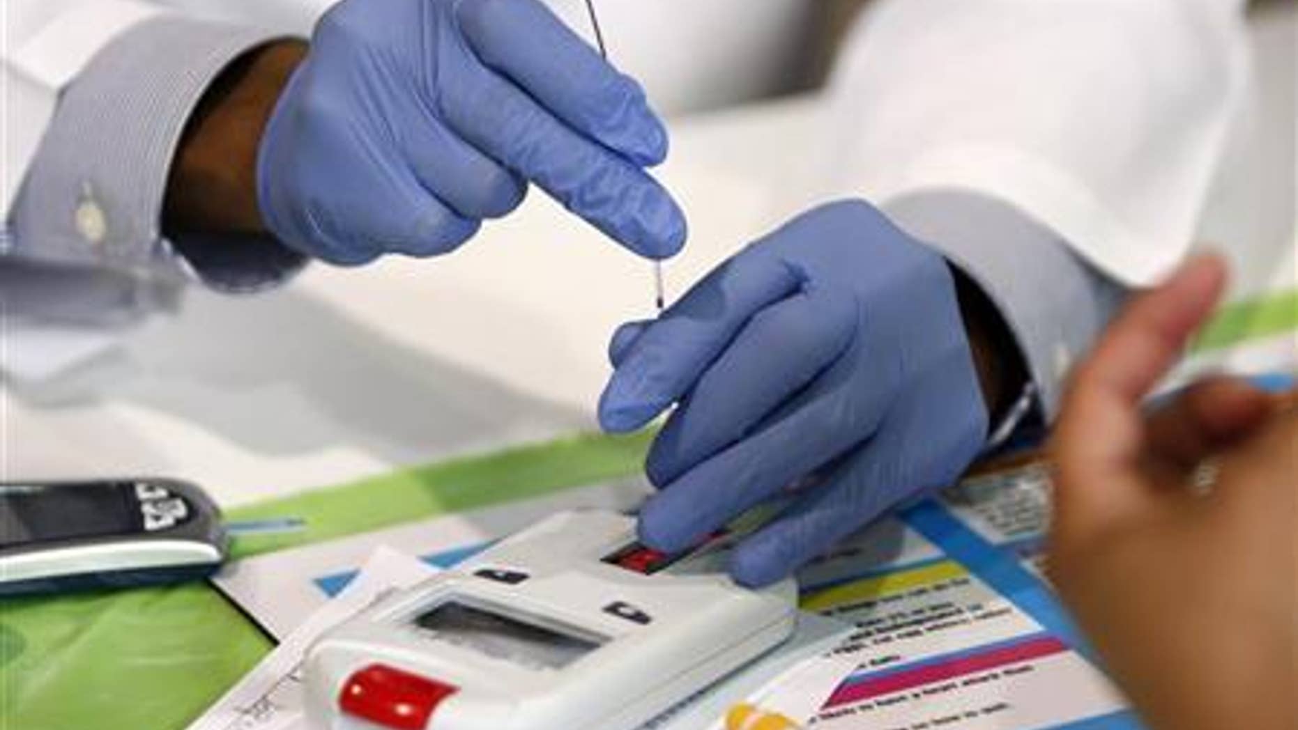 A medical assistant uses a machine that measures cholesterol during a free health screening at the Mayor's Back to School Fair in Dallas, Texas August 6, 2009. REUTERS/Jessica Rinaldi
