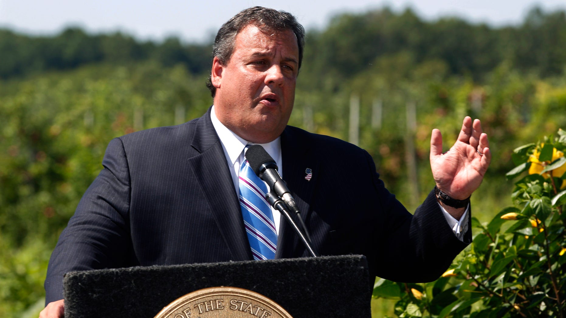 New Jersey Gov. Chris Christie stands near an orchard as he addresses a gathering Wednesday, Aug. 17, 2011, at Terhune Orchard in Princeton, N.J.