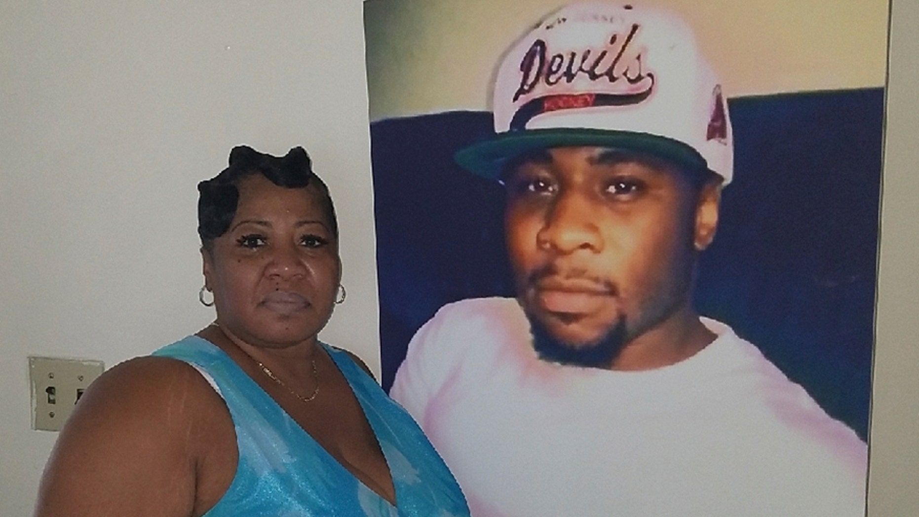 June Rodgers in front of a picture of her son Christian.