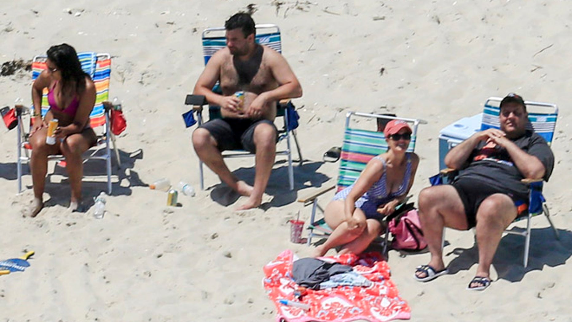 In this Sunday, July 2, 2017, photo, New Jersey Gov. Chris Christie, right, uses the beach with his family and friends at the governor's summer house at Island Beach State Park in New Jersey. Christie is defending his use of the beach, closed to the public during New Jersey's government shutdown, saying he had previously announced his vacation plans and the media had simply "caught a politician keeping his word." (Andrew Mills/NJ Advance Media via AP)