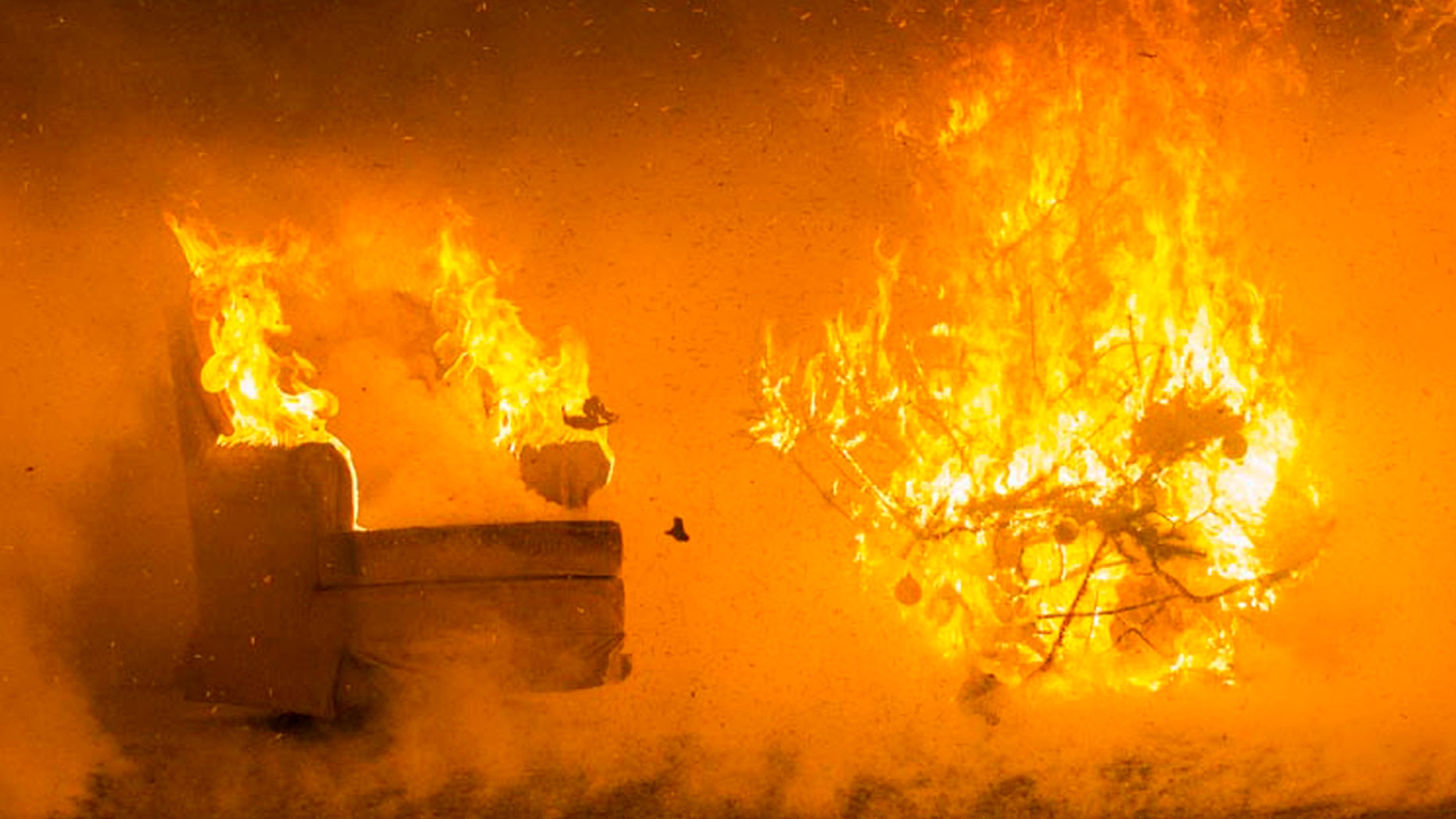 In this Tuesday, Nov. 29, 2016 photo flames engulf the wall and ceiling of a room as well as items in the room thirty-five seconds into the ignition of a Christmas tree during a test burn by the fire protection engineering lab at the Worcester Polytechnic Institute, in Worcester, Mass.