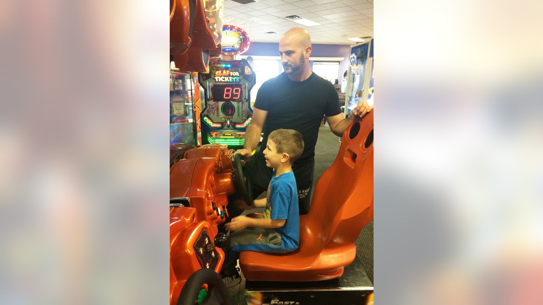 Austin Moniz, and his dad, Michael Moniz, enjoy playing a driving game during Sensory Sensitive Sunday at Chuck E. Cheese’s.