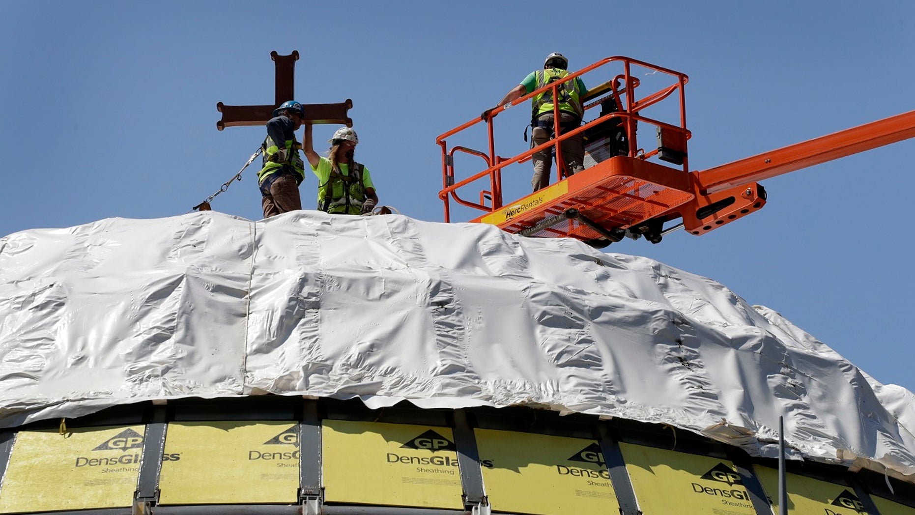 File 2017: Construction workers adjust a temporary cross on the St. Nicholas National Shrine in New York. Work on the Greek Orthodox church destroyed in the Sept. 11 attacks has been stopped amid financial difficulties and questions over how funds have been managed.