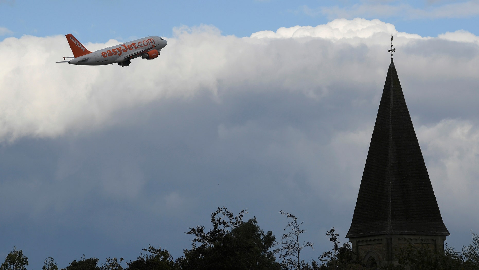 File photo - An EasyJet passenger aircraft is seen behind a church steeple as it takes off from Gatwick Airport in southern England, Britain, Oct. 9, 2016. (REUTERS/Toby Melville)