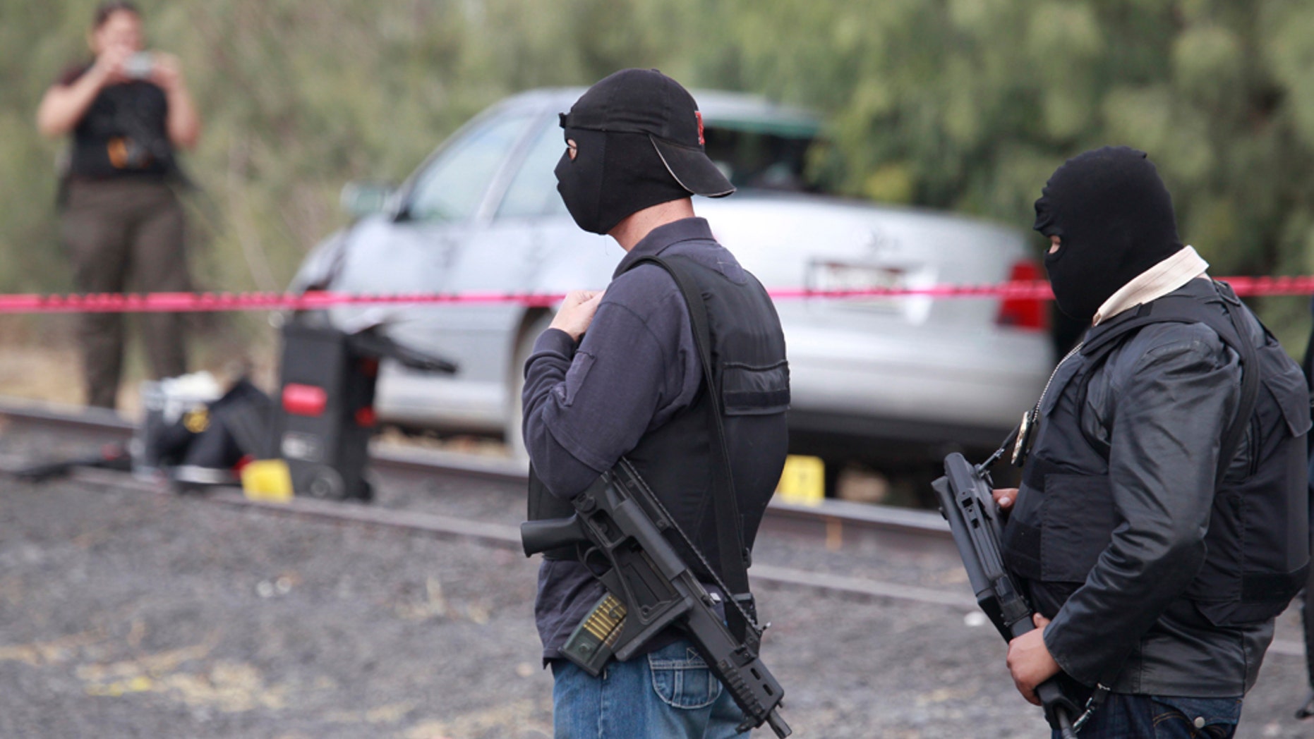 Investigative police stand by a vehicle that was allegedly abandoned by men suspected of shooting two of their fellow officers the northern border city of Ciudad Juarez, Mexico Monday Dec. 6, 2010. One investigative police officer died in the shooting, according to police. (AP Photo/Dario Lopez-Mills)