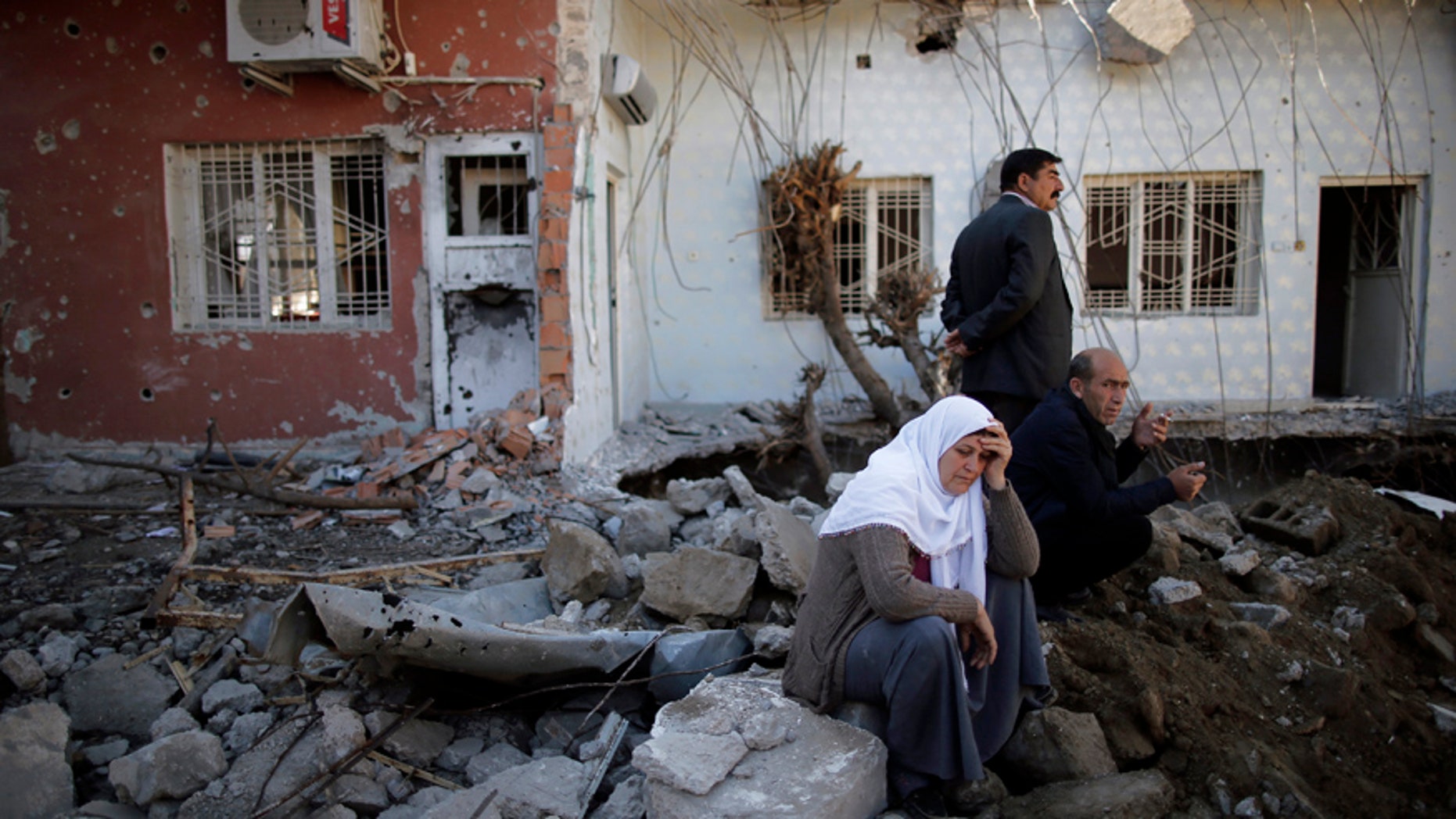 March 2, 2016: People look at their ruined houses in Cizre, Turkey.
