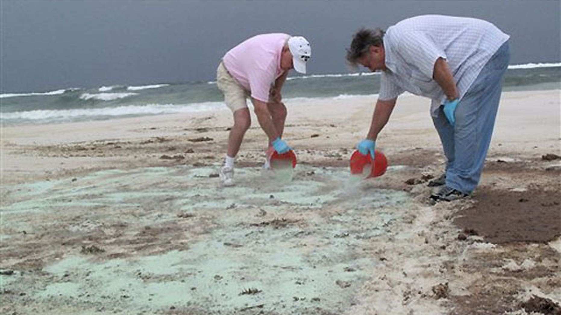 July 1: Workers demonstrate a sand-cleaning technology, called Green Tech, for evaluators from Florida's Department of Environmental Protection and BP on Pensacola Beach.