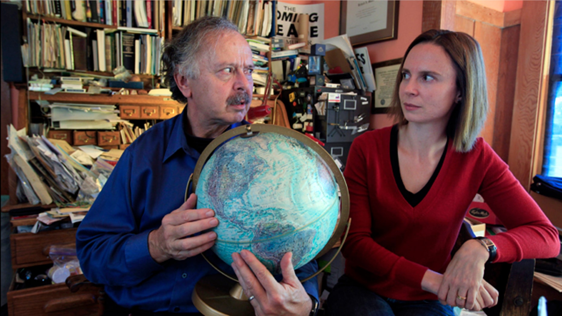 Richard Muller, left, and his daughter, Elizabeth Muller, hold a globe as they talk about their study on climate at their home in Berkeley, Calif.