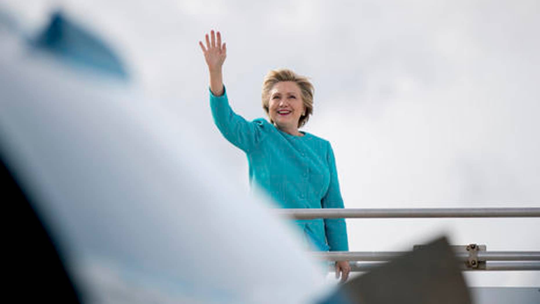 Democratic presidential candidate Hillary Clinton waves before boarding her campaign plane at Miami International Airport in Miami, Wednesday, Oct. 26, 2016, to travel to Lake Worth, Fla. for a rally.