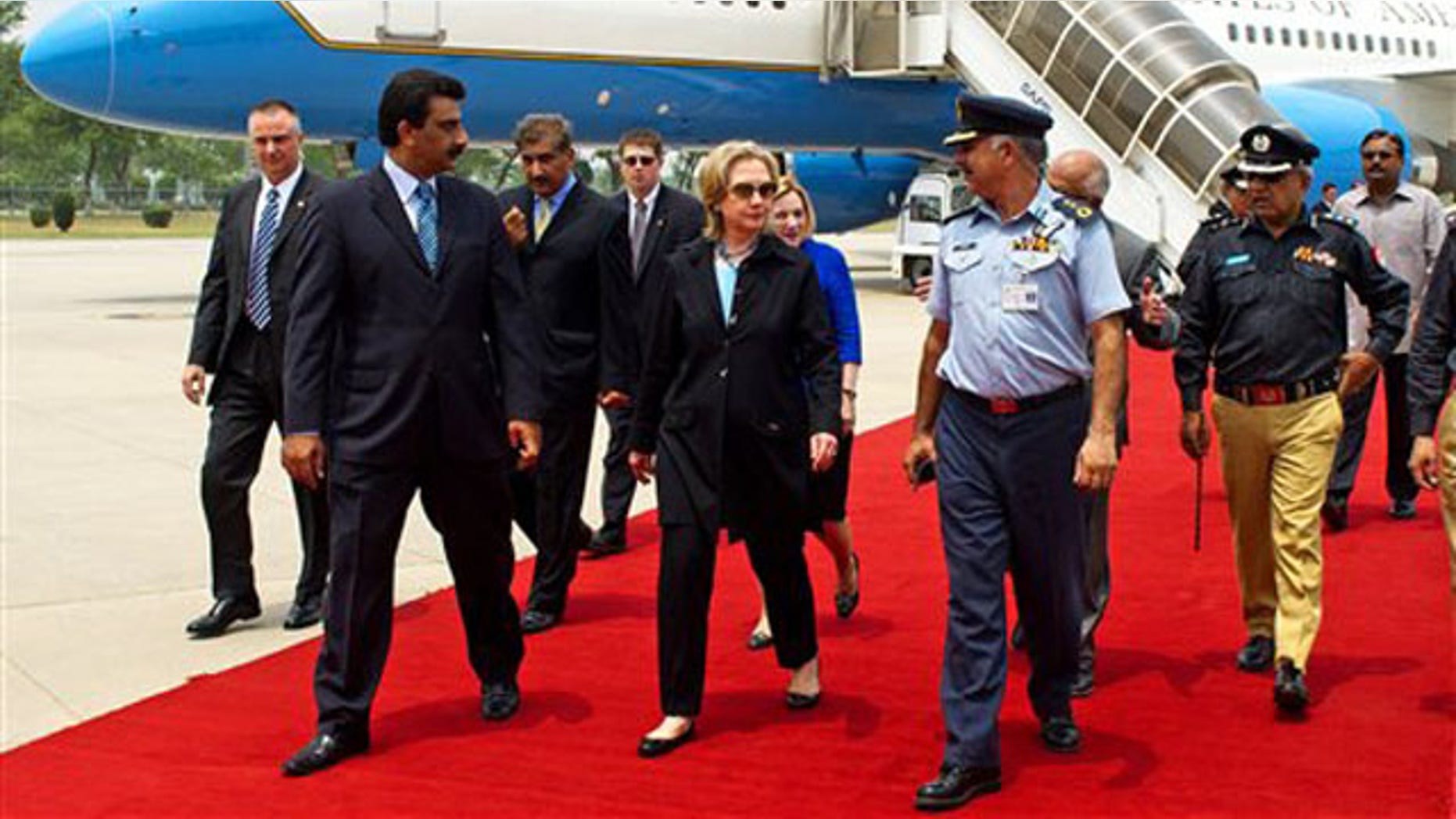 Secretary of State Hillary Clinton, center, walks on the red carpet upon her arrival at PAF Base Chakala in Islamabad July 18. (AP Photo)