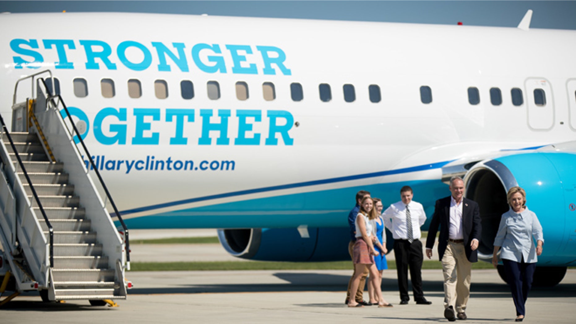 Democratic presidential candidate Hillary Clinton, right, accompanied by Democratic vice presidential candidate, Sen. Tim Kaine, D-Va., second from right, walks across the tarmac as Clinton arrives at Cleveland Hopkins International Airport in Cleveland, Ohio, Monday, Sept. 5, 2016, after traveling from Westchester County Airport in White Plains, N.Y. (AP Photo/Andrew Harnik)
