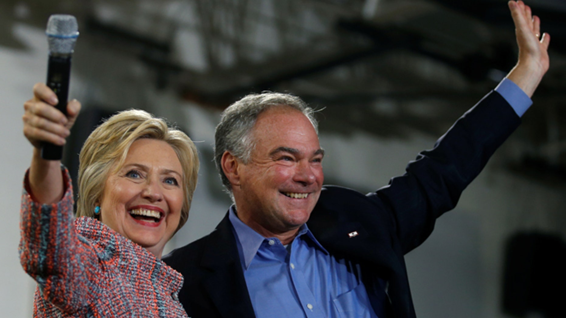 Democratic U.S. presidential candidate Hillary Clinton and U.S. Senator Tim Kaine (D-VA) wave to the crowd during a campaign rally at Ernst Community Cultural Center in Annandale, Virginia, U.S., July 14, 2016. REUTERS/Carlos Barria - RTSHZ26