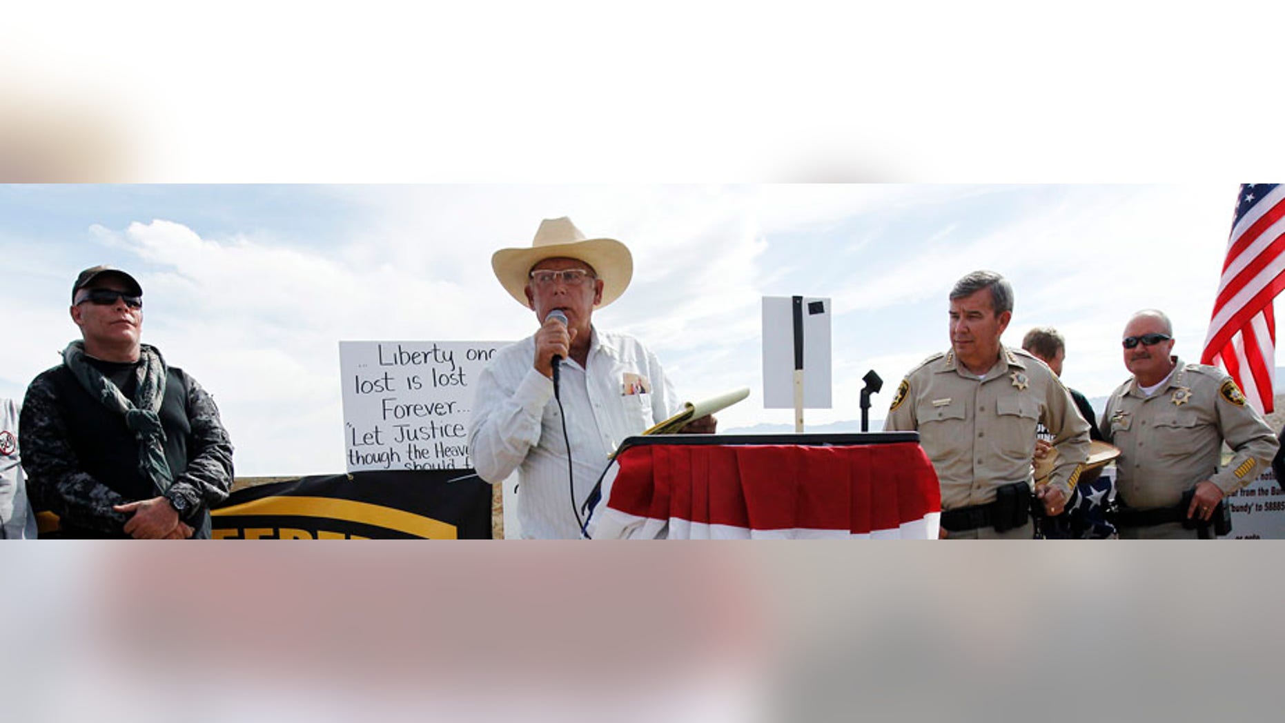 Rancher Cliven Bundy, middle, addresses his supporters along side Clark County Sheriff Doug Gillespie, right, on April 12, 2014. Bundy informed the public that the BLM has agreed to cease the roundup of his family's cattle.(AP Photo/Las Vegas Review-Journal, Jason Bean)