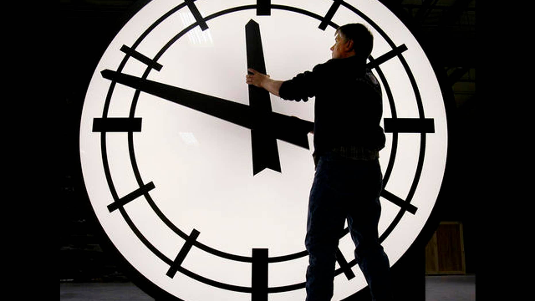 Electric Time machinist Scott Gow prepares to remove the hands of an eight-foot clock being shipped to the Ashley Furniture company in Kenosha, Wis., at the Electric Clock factory in Medfield Mass., Friday morning, March 9, 2007. Daylight saving time begins Sunday morning March 11, 2007, three weeks earlier than it has for the past two decades due to a 2005 law taking effect this year. (AP Photo/Stephan Savoia)