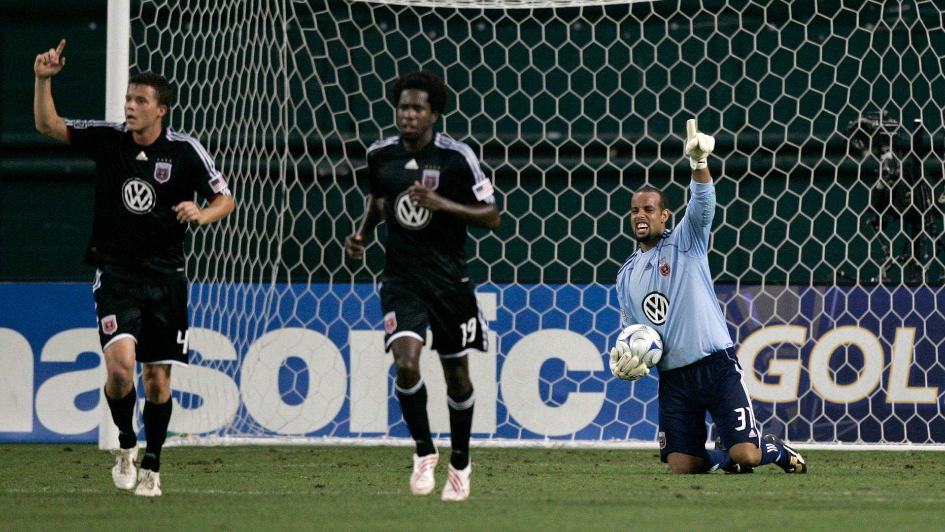 DC United's goalie Josh Wicks (R) gestures after making a save with teammates Marc Burch (L) and Clyde Simms (C) during their MLS soccer match against Chicago Fire in Washington June 13, 2009. REUTERS/Hyungwon Kang (UNITED STATES SPORT SOCCER) - RTR24N13