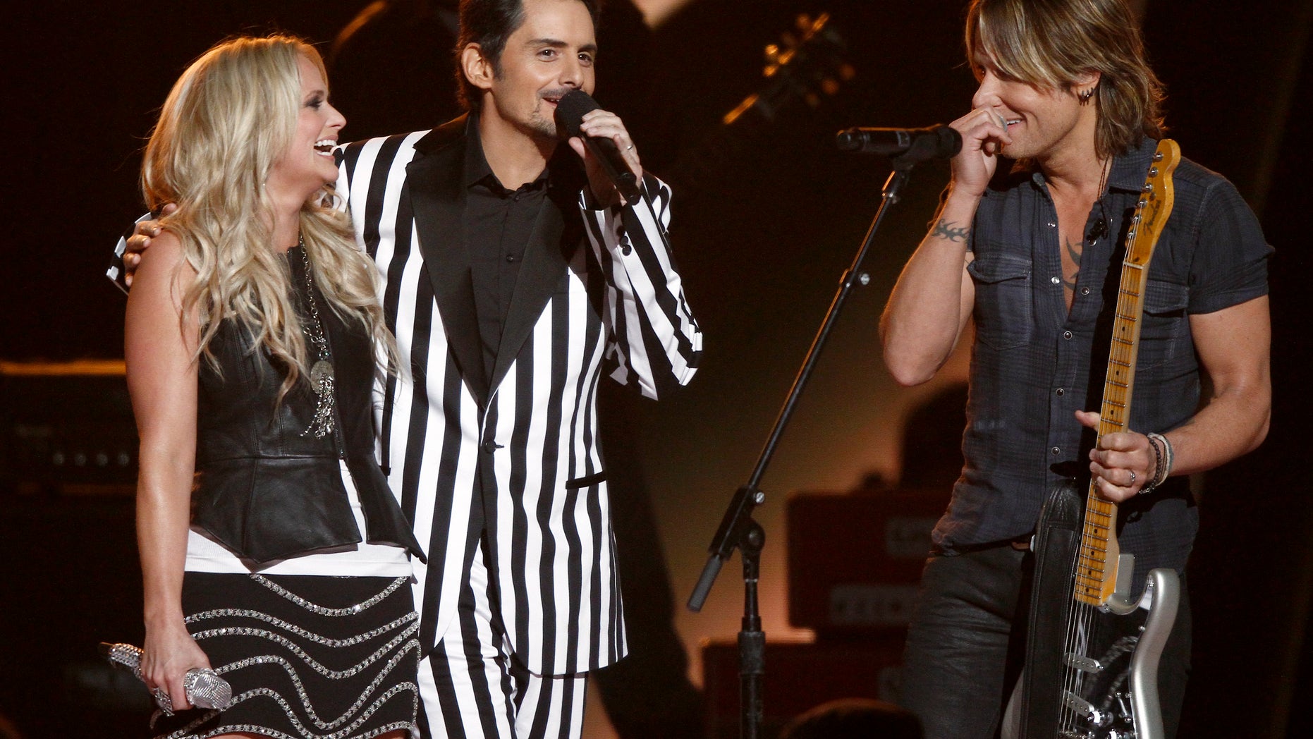 Miranda Lambert, left, Brad Paisley, center, and Keith Urban appear onstage at the 47th annual CMA Awards at Bridgestone Arena on Wednesday, Nov. 6, 2013, in Nashville, Tenn. (Photo by Wade Payne/Invision/AP)