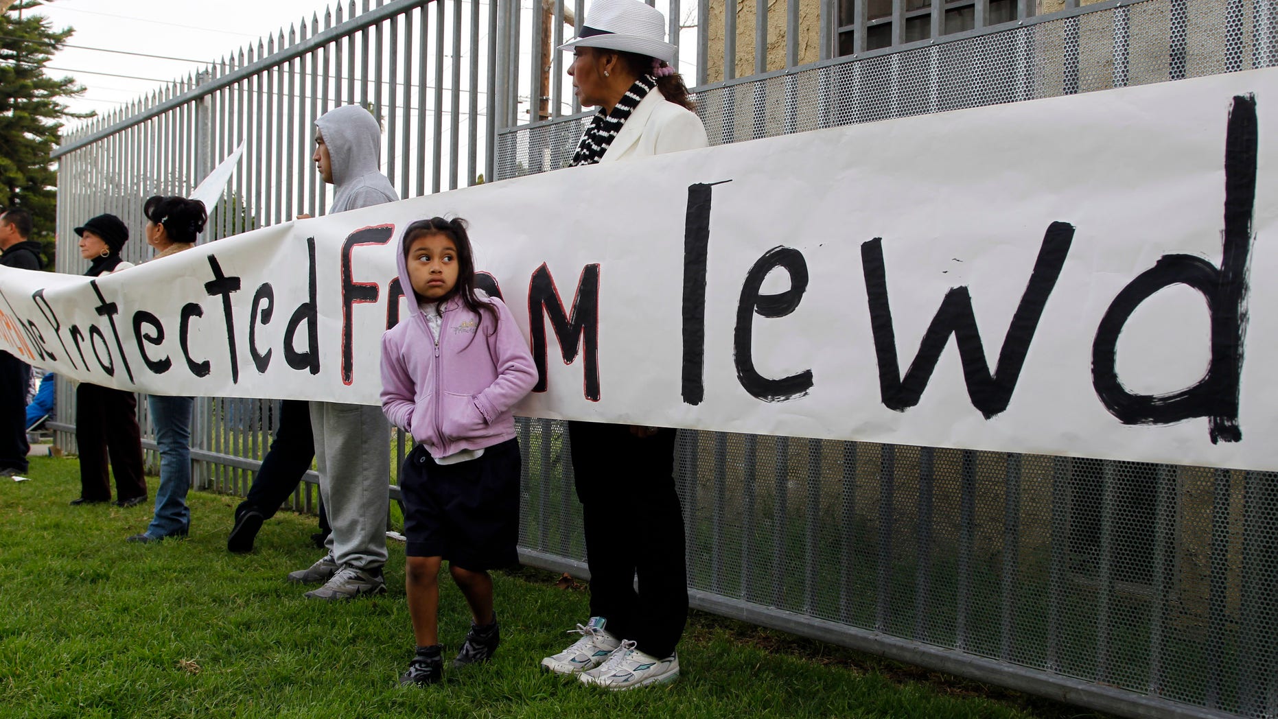 Ivis Urbina, right, with her granddaughter Alexa Agillon, 6, protest with others outside Miramonte Elementary school in Los Angeles Monday, Feb. 6, 2012.