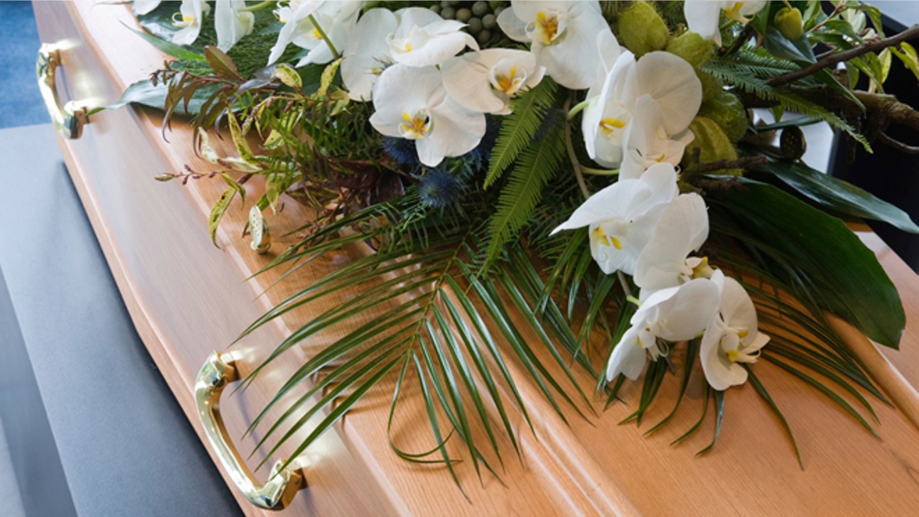 A coffin with a flower arrangement in a morgue