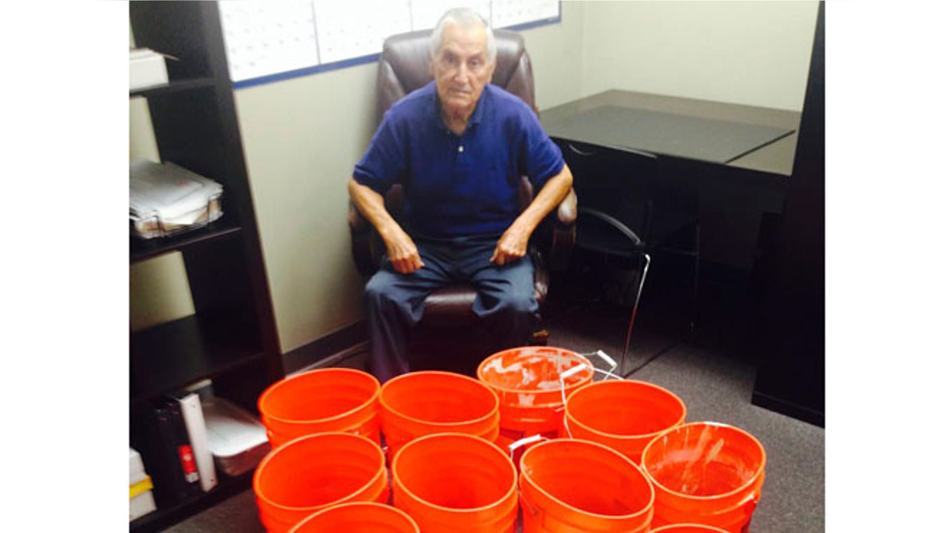 July 31, 2014: This image provided by Andres Carrasco shows him in his office in Los Angeles with buckets of change he won as a partial settlement in a 2012 lawsuit against Adrianas Insurance Services, a Rancho Cucamonga, Calif.-based company.