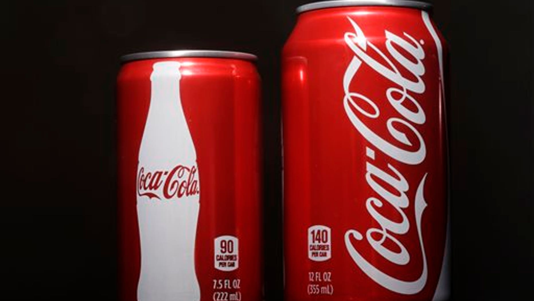In this Jan. 12, 2015 file photo, a 7.5-ounce can of Coca-cola, left, is posed next to a 12-ounce can for comparison. (AP Photo/Matt Rourke, File)