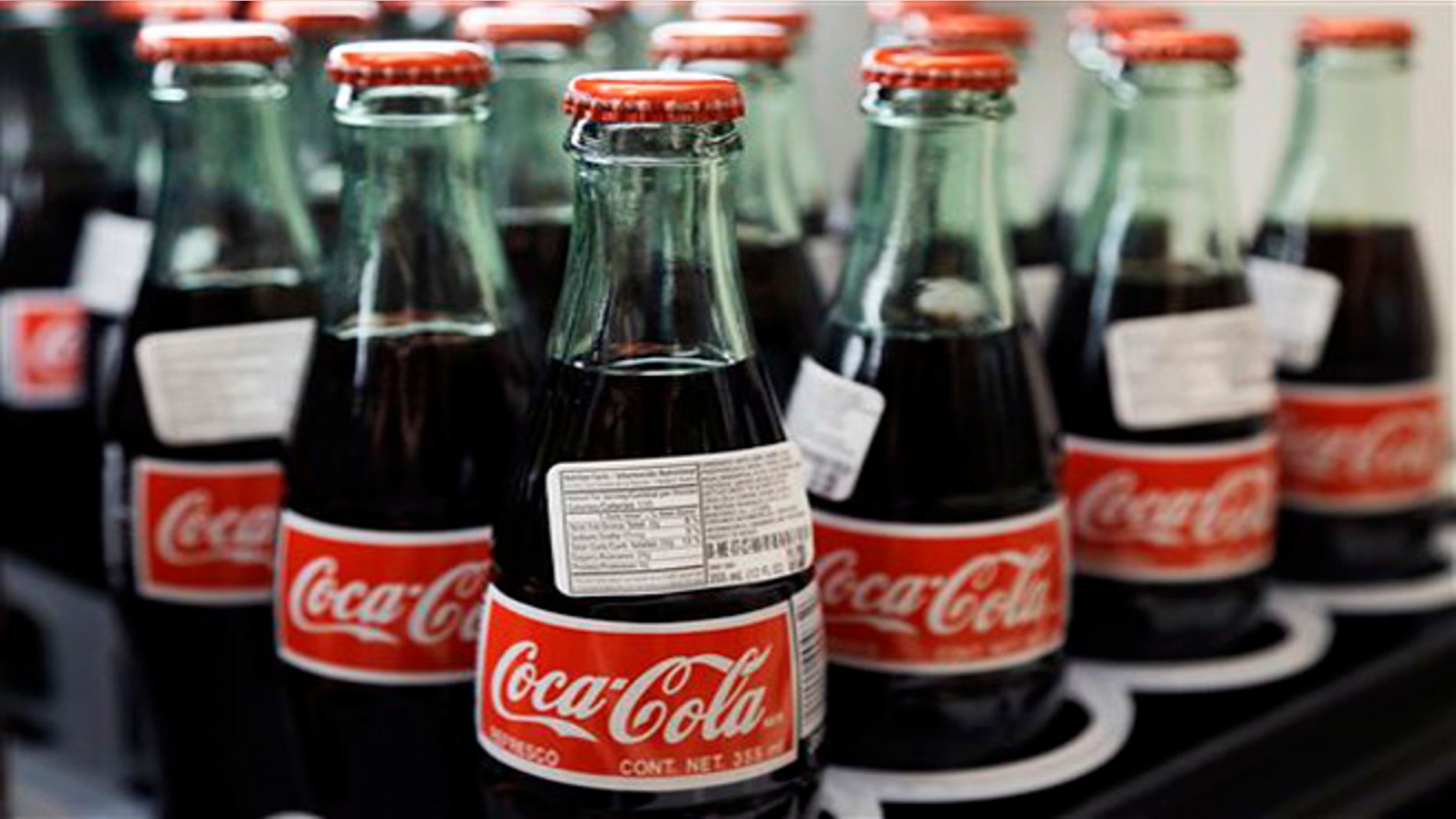 In this July 9, 2015 photo, bottles of Coca-Cola are on display at a Haverhill, Massachusetts.