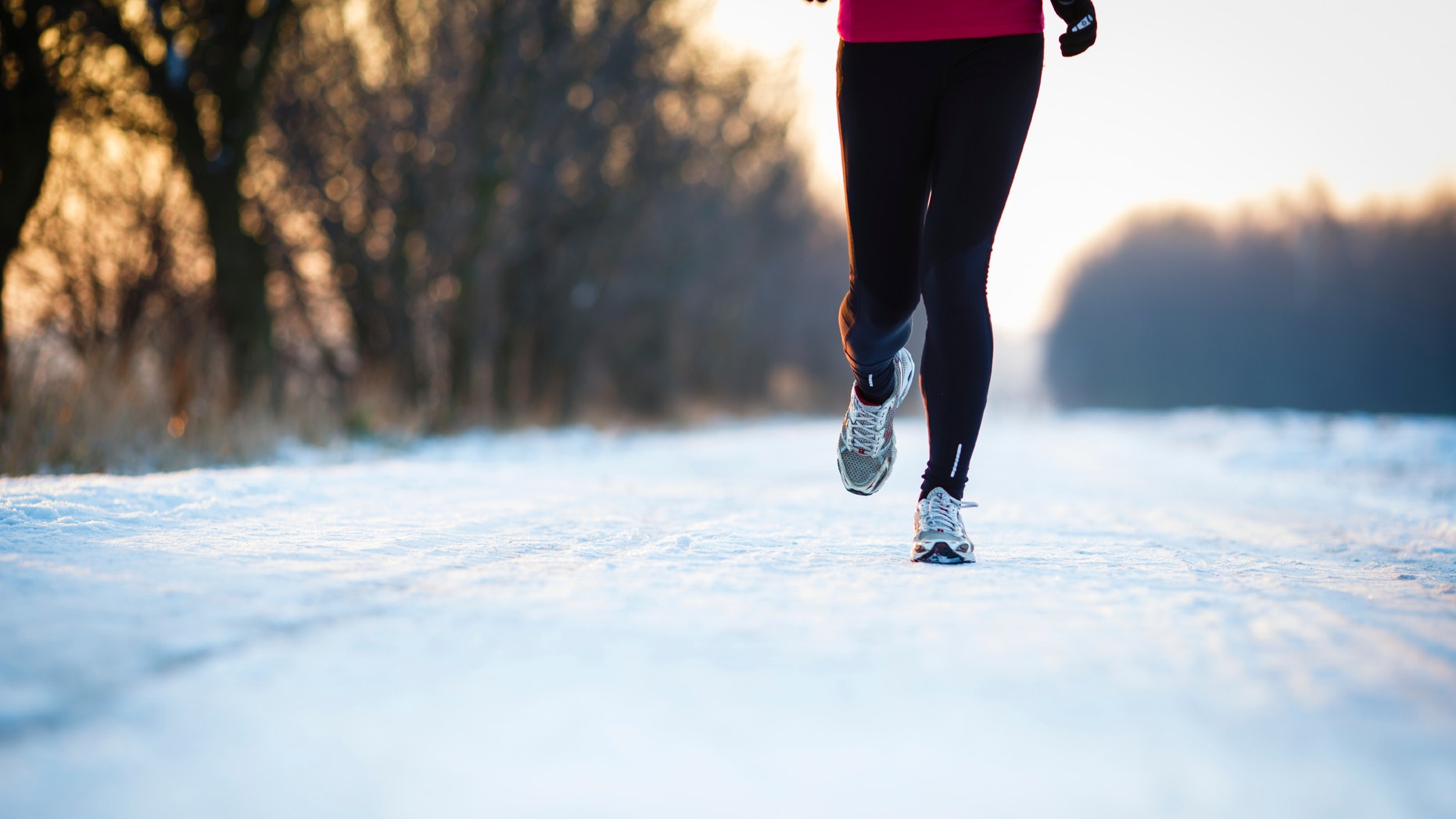 Winter running - Young woman running outdoors on a cold winter day