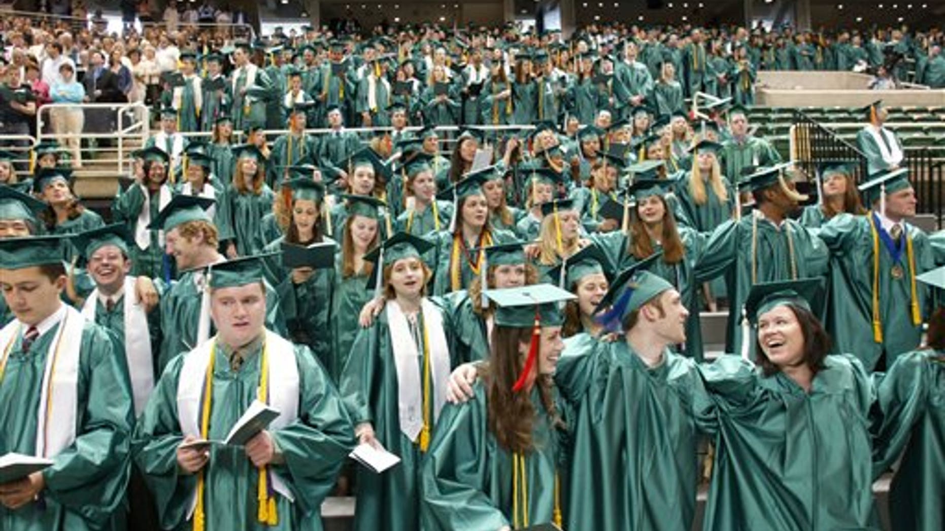 Michigan State University graduates as they sing their school's Alma Mater at the close of convocation ceremonies in East Lansing, Mich.