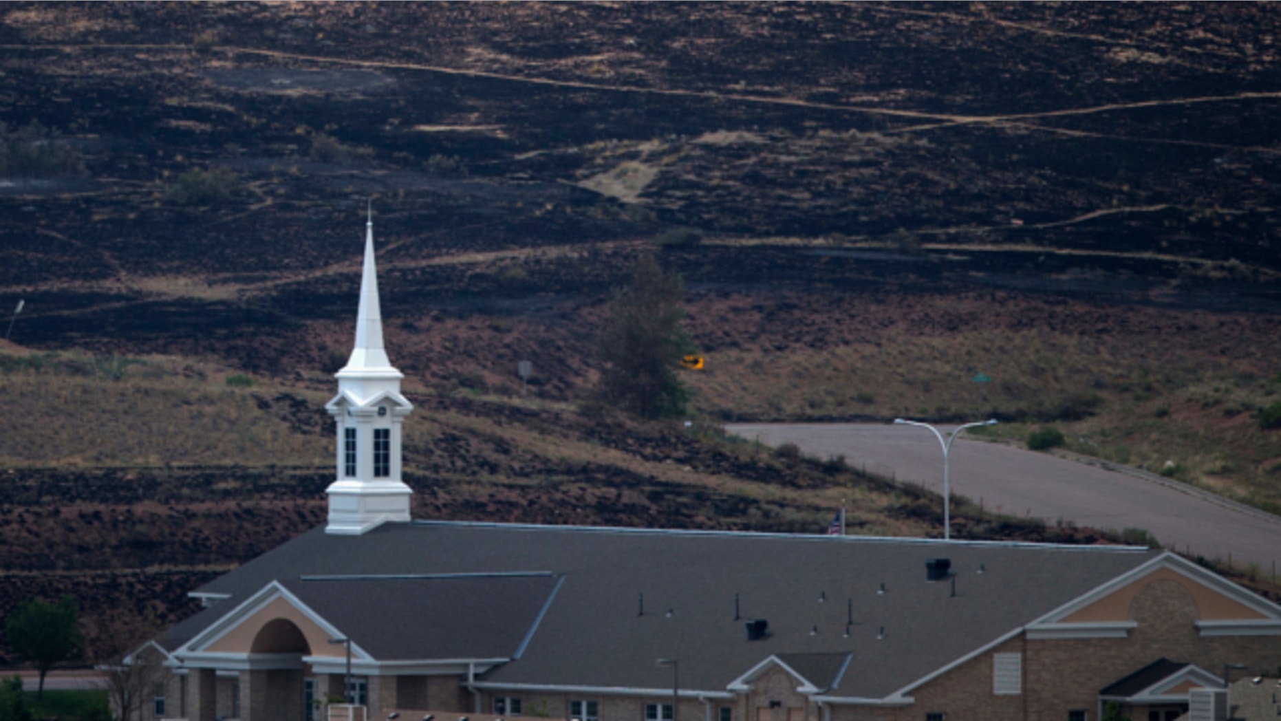 FILE: June 30, 2012. A church, which survived the Waldo Canyon Fire, is backdropped by a charred hillside in Colorado Springs, Colorado.