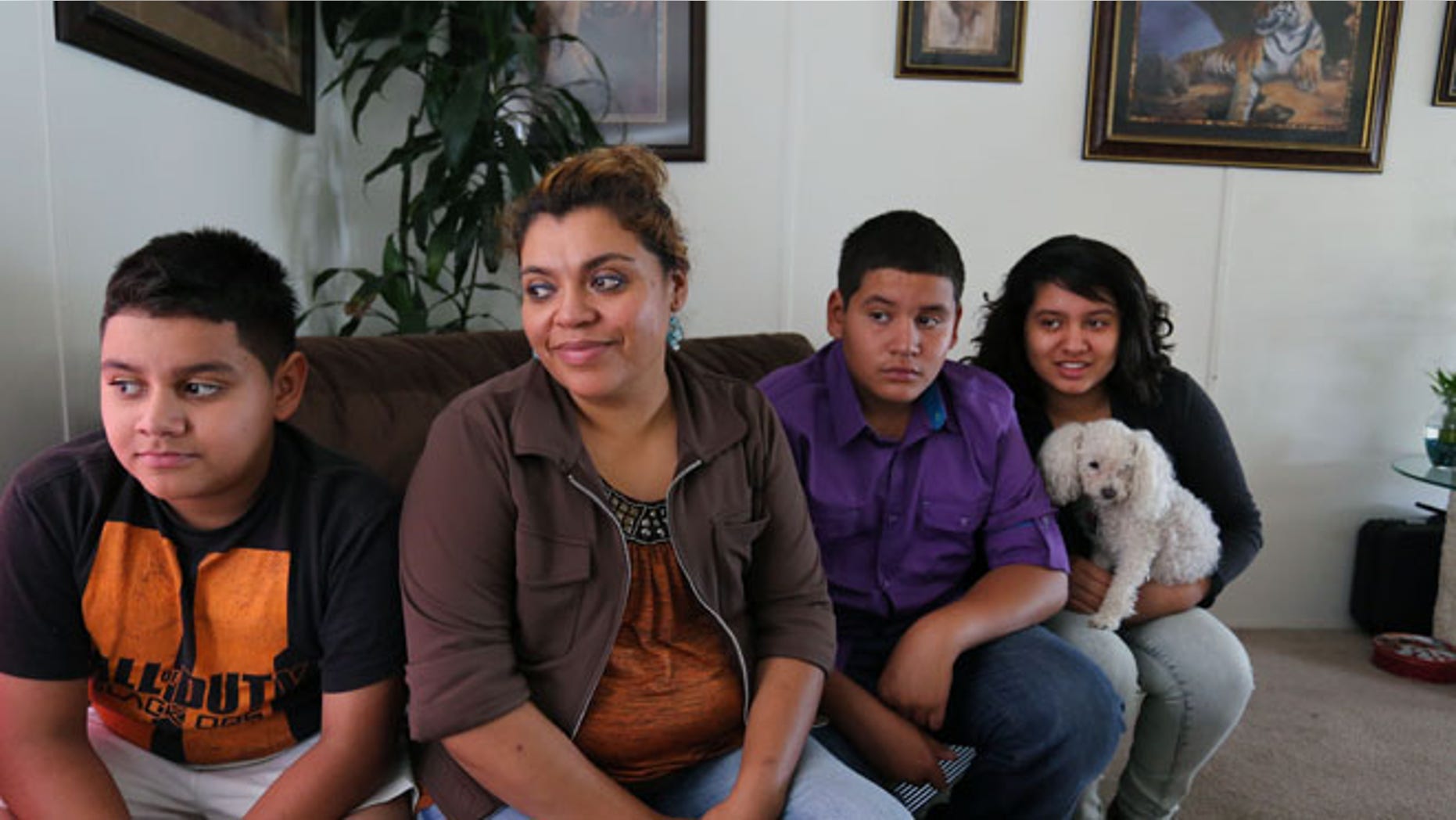 July 31, 2014: Adriana Gaytan, who came to Colorado in 1997 from the Mexican state of Zacatecas, second from left, sits at home with her children who were born in the U.S. from left to right, Osbaldo, 11, Oscar 13, Indhira, 14, and their dog Kissy, in Aurora, Colo.