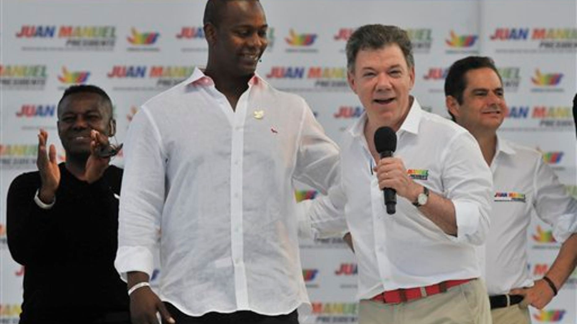 Colombia's President Juan Manuel Santos speaks next to retired baseball player Edgar Renteria during a campaign rally at the Tomas Arrieta baseball stadium in Barranquilla, Colombia, Sunday, March 16, 2014. Santos, who is running for re-election, said on a televised statement on Tuesday, March 18, that he suffered an accident of incontinence product of surgery he underwent a year and a half ago to remove prostate cancer, that according to his doctor the accident is normal in patients who have suffered such intervention and that his health is optimal. (AP Photo)