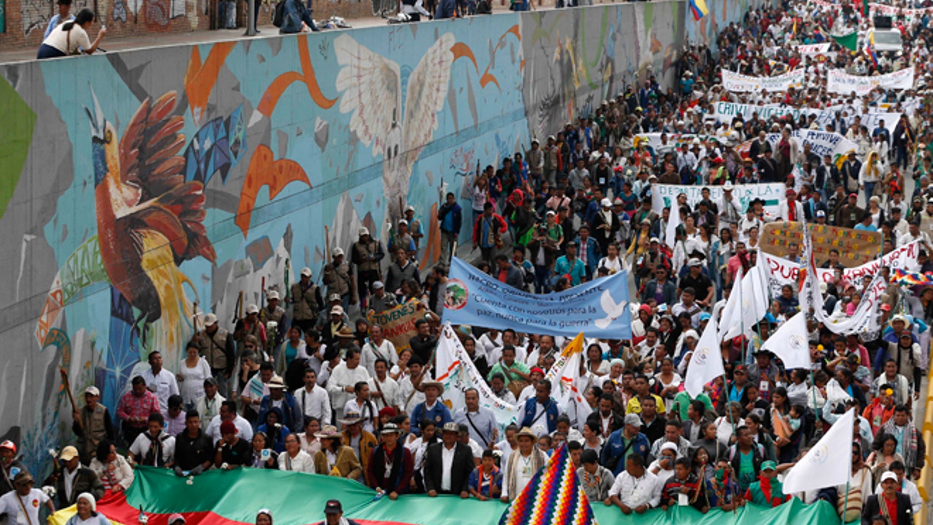 People participate in a peace march in Bogota, Colombia, Wednesday, Oct. 12, 2016. Thousands of rural farmers, indigenous activists and students marched in cities across Colombia to demand a peace deal between the government an leftist rebels no be scuttled. (AP Photo/Fernando Vergara)