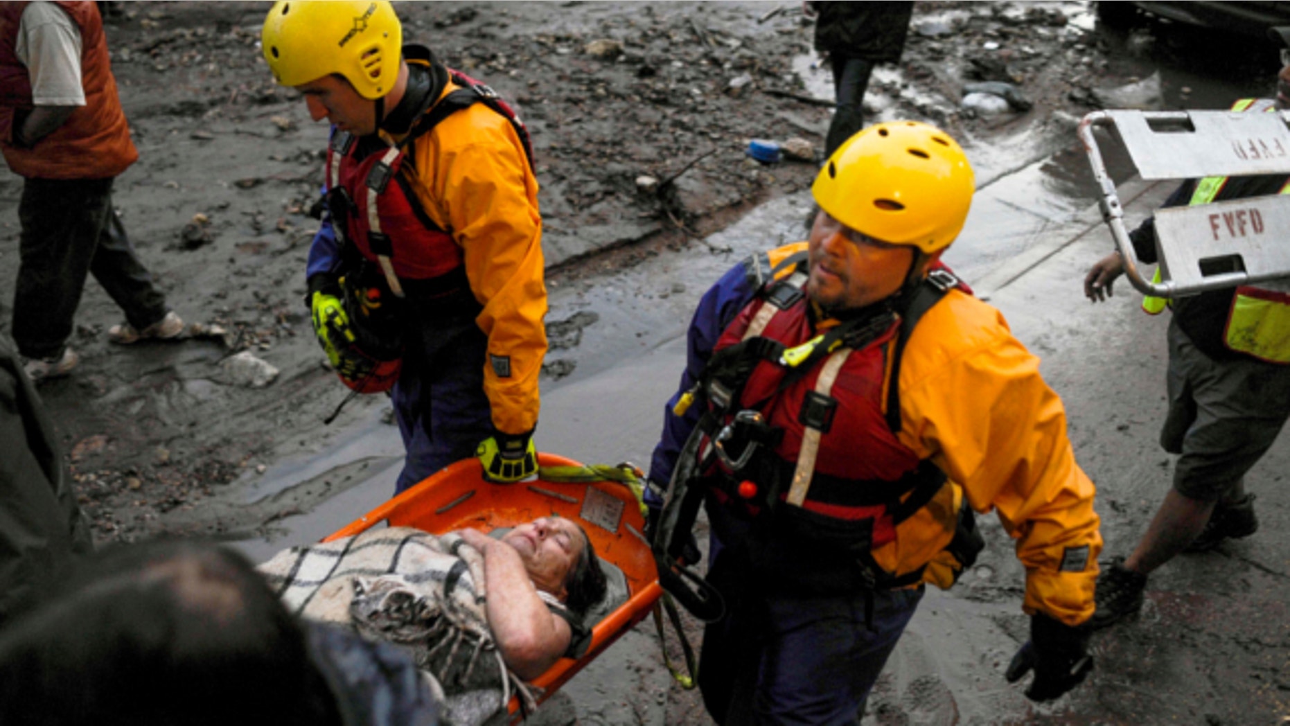 Aug. 9, 2013: The Fountain Water Rescue team assists a woman down Canon Avenues after she broke her leg climbing to safety to avoid the flash flood that ripped through downtown in Manitou, Colo.